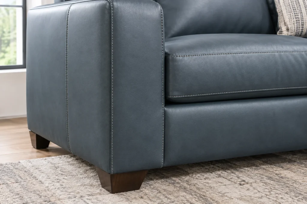 Close-up of Ashley Bolsena sofa leather stitching and wood-finish legs