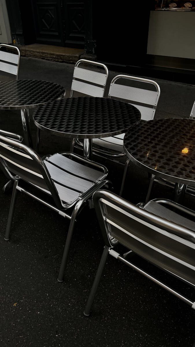 Metal chairs and tables lined up outside a Paris café.