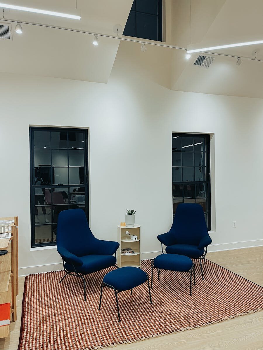 Contemporary lounge setup with blue armchairs and minimalist decor, perfect for stylish interiors.