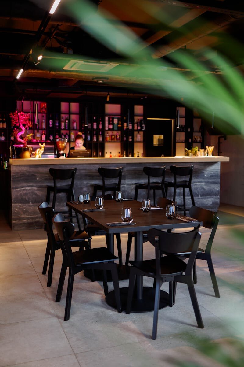 Chic modern restaurant interior featuring a stylish bar and dining area with elegant seating.