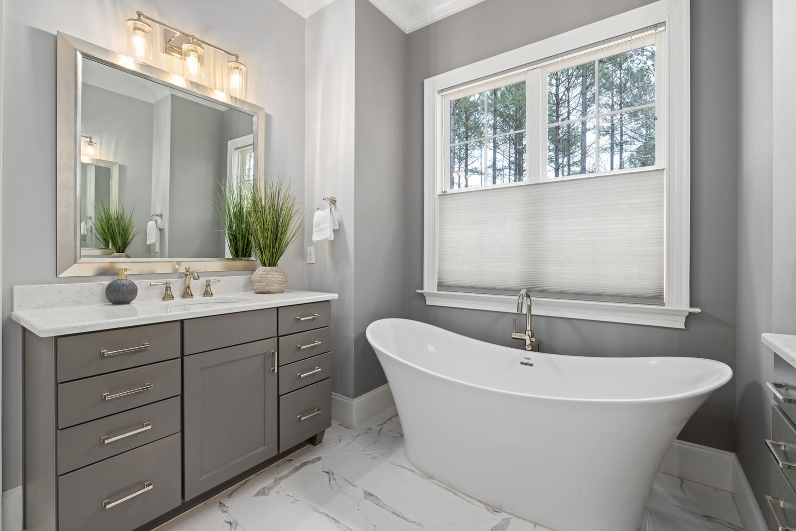 Elegant bathroom with a freestanding tub and stylish vanity featuring a mirror and modern lighting.