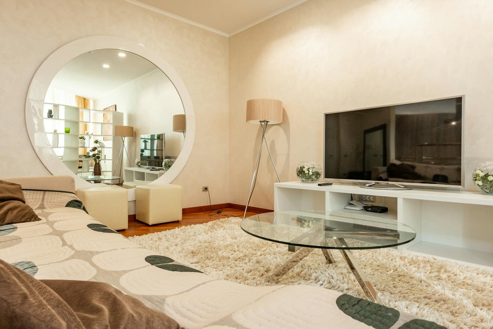 Interior of modern living room with round shaped mirror and couch with pattern