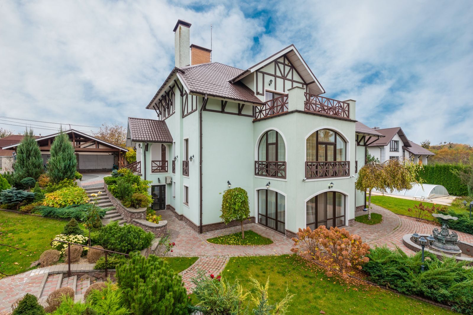 Stunning suburban home with lush garden and modern architectural design, featuring spacious balconies.