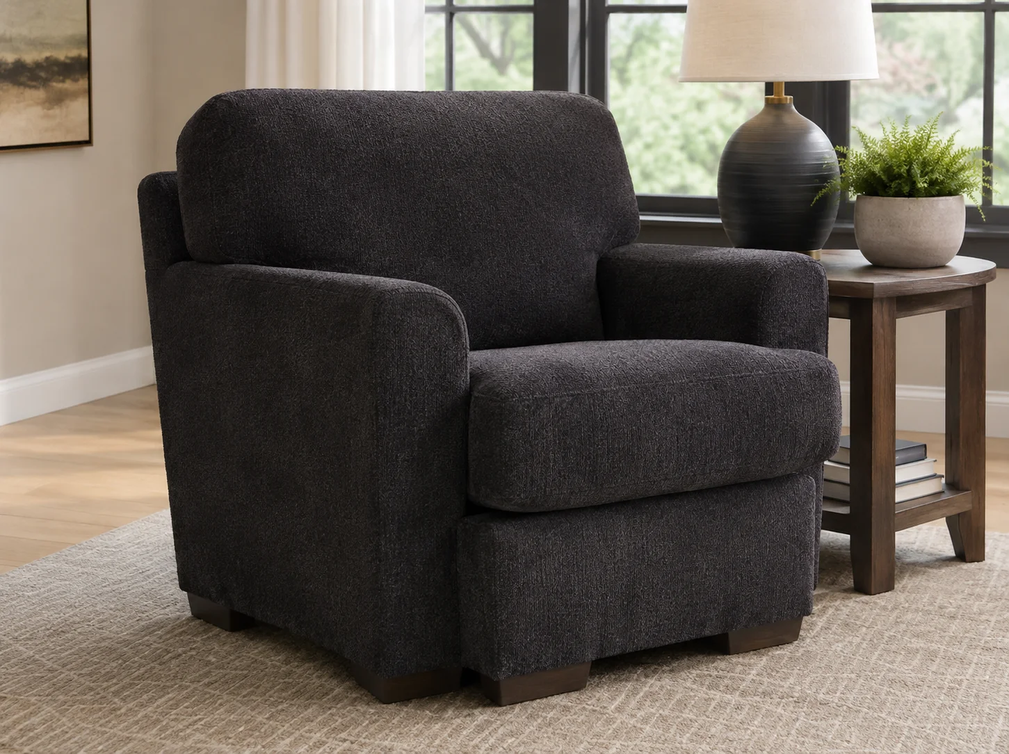 Ashley Furniture Adlai Chair in dark charcoal upholstery styled in a modern living room with a wooden side table.