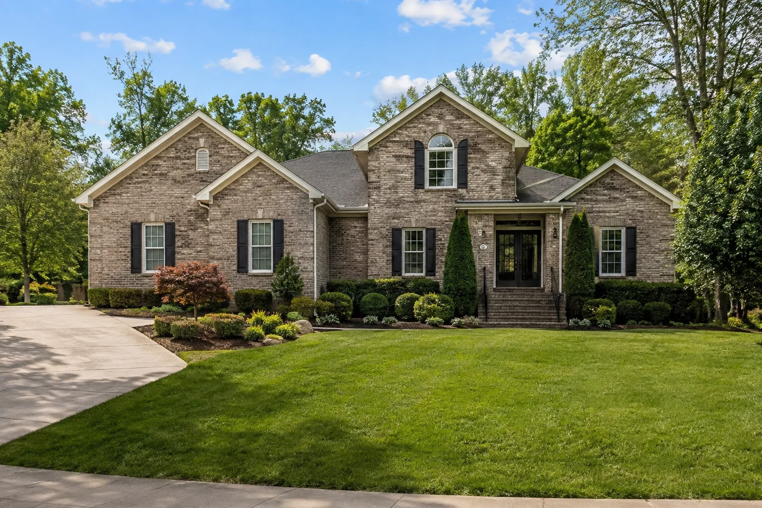 : Beautiful brick real estate home for sale in Hoover, AL 35244, featuring a spacious front lawn, landscaped garden, and suburban residential setting.