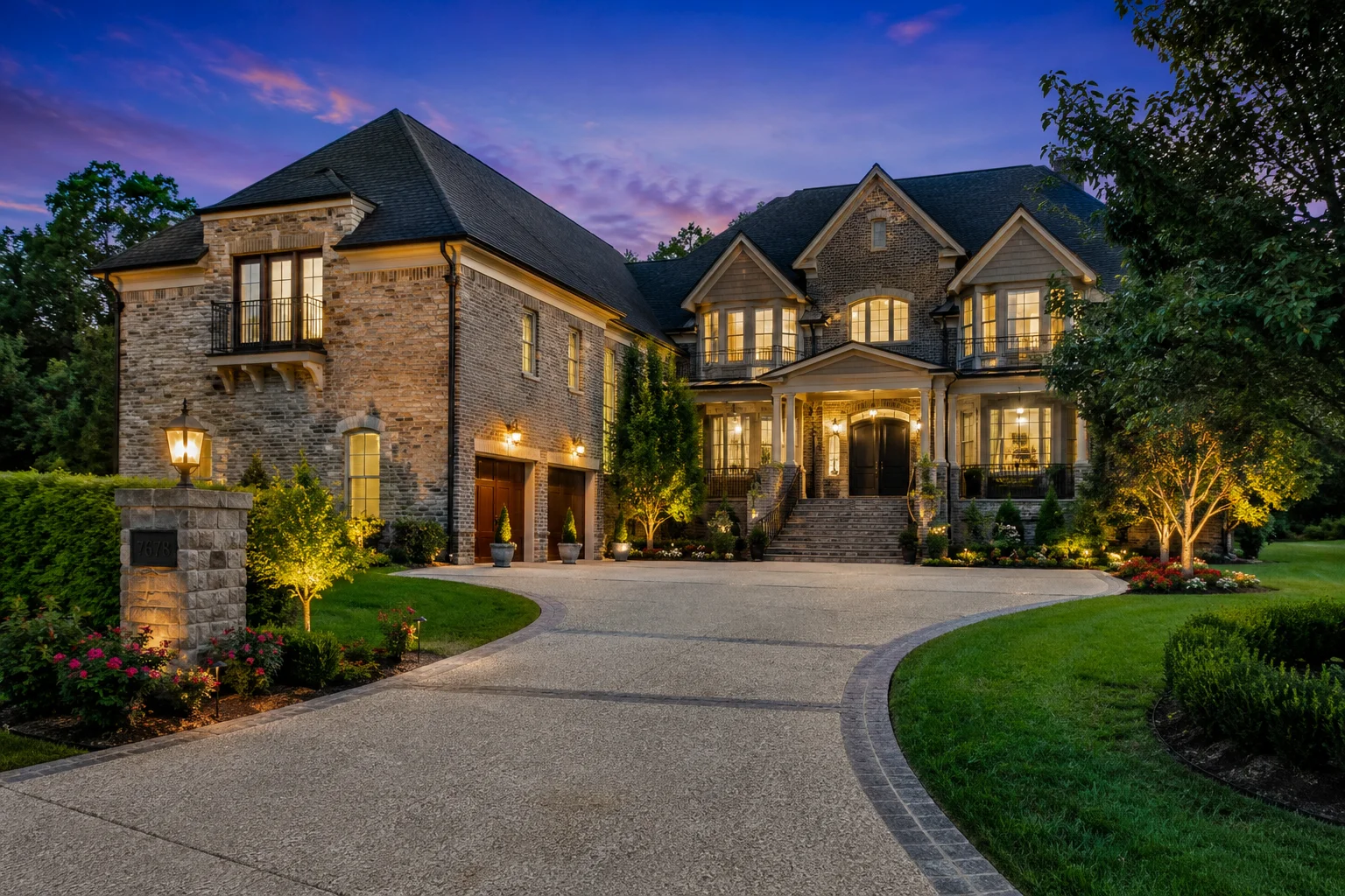 Luxury brick home exterior at 7678 Sawyer Brown Rd in Nashville, Tennessee, with landscaped grounds and elegant driveway at twilight.