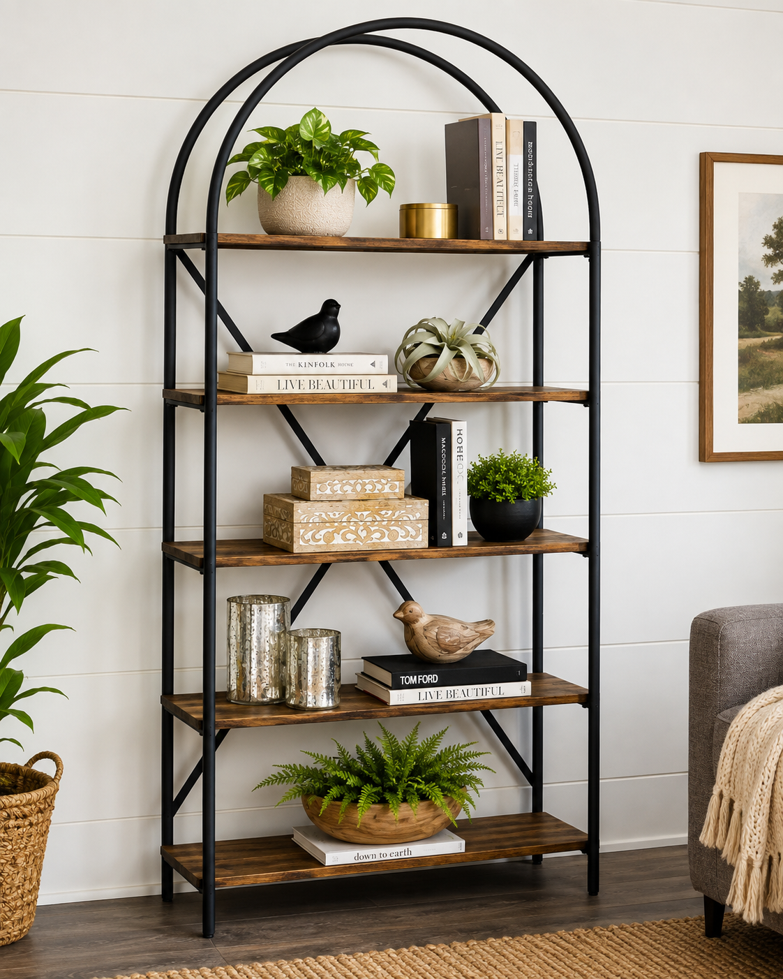 Ashley Galtbury Bookcase with rustic wood shelves and black metal frame, styled with plants, books, and decorative accents in a modern living room.