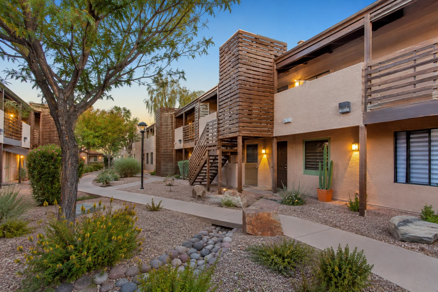 Treehouse Apartments in Tucson, AZ featuring a modern Southwestern-style apartment courtyard with wooden balconies, desert landscaping, and outdoor walkways.