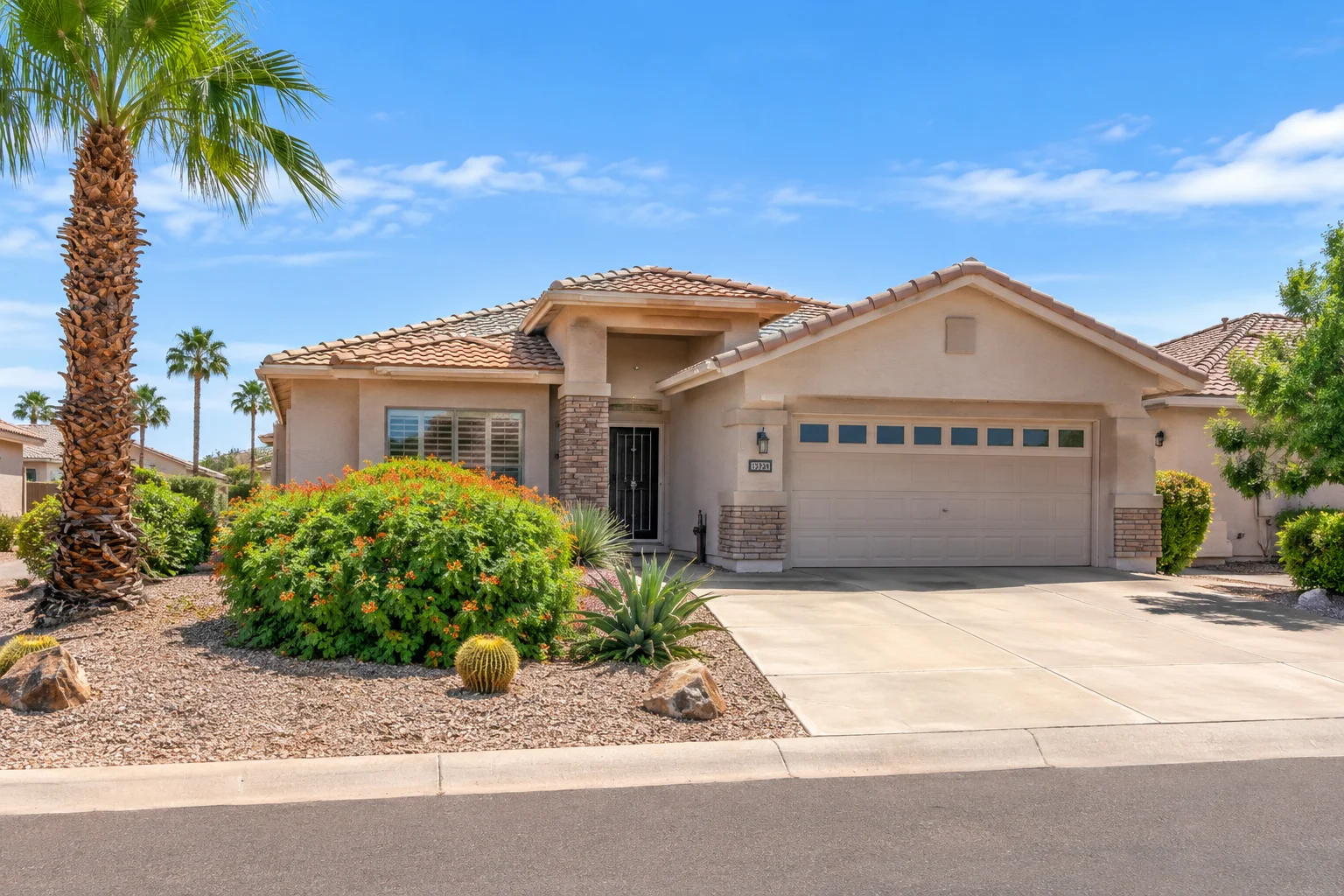 Sun City West, Arizona home for sale with Southwestern architecture, desert landscaping, palm trees, and tiled roof