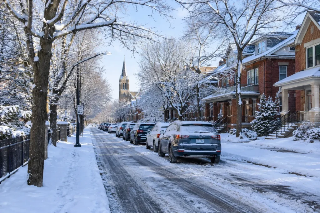 Snow-covered residential street with parked cars in Saint Paul during winter