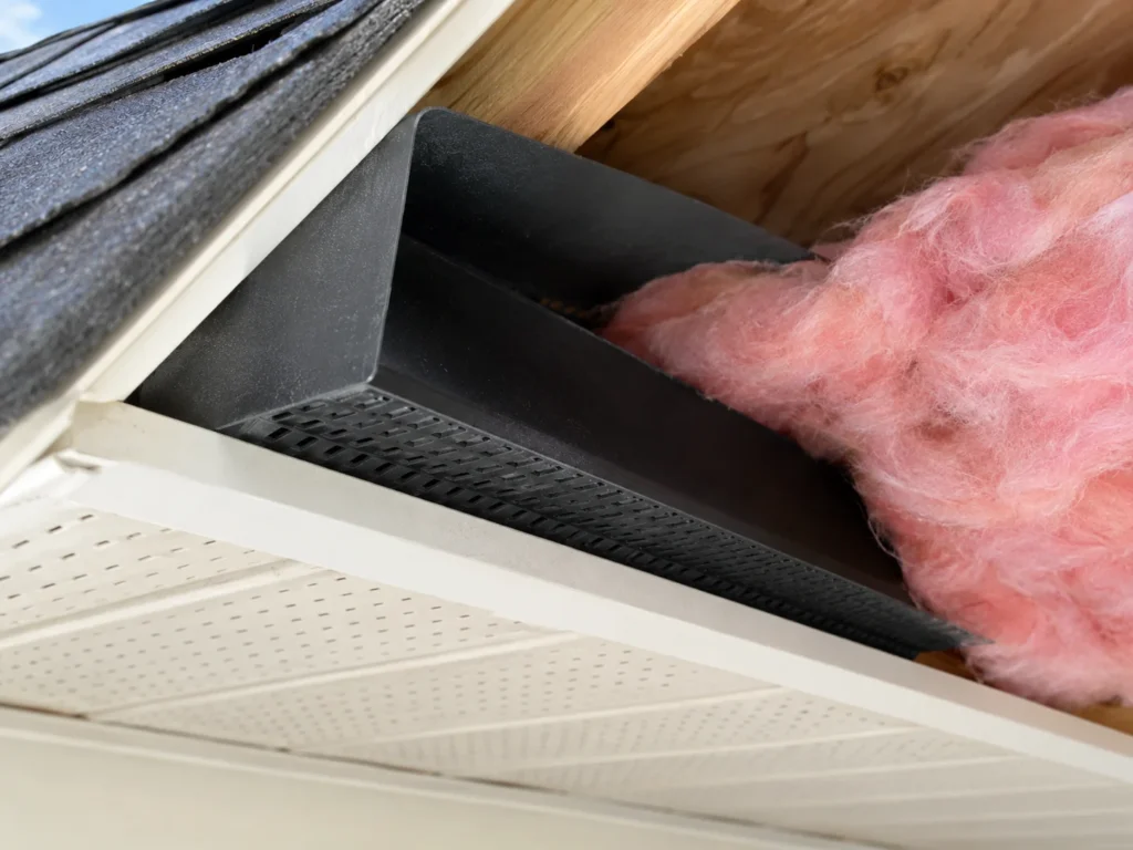 Rafter baffle stapled between two rafters keeping insulation clear of the soffit vent opening