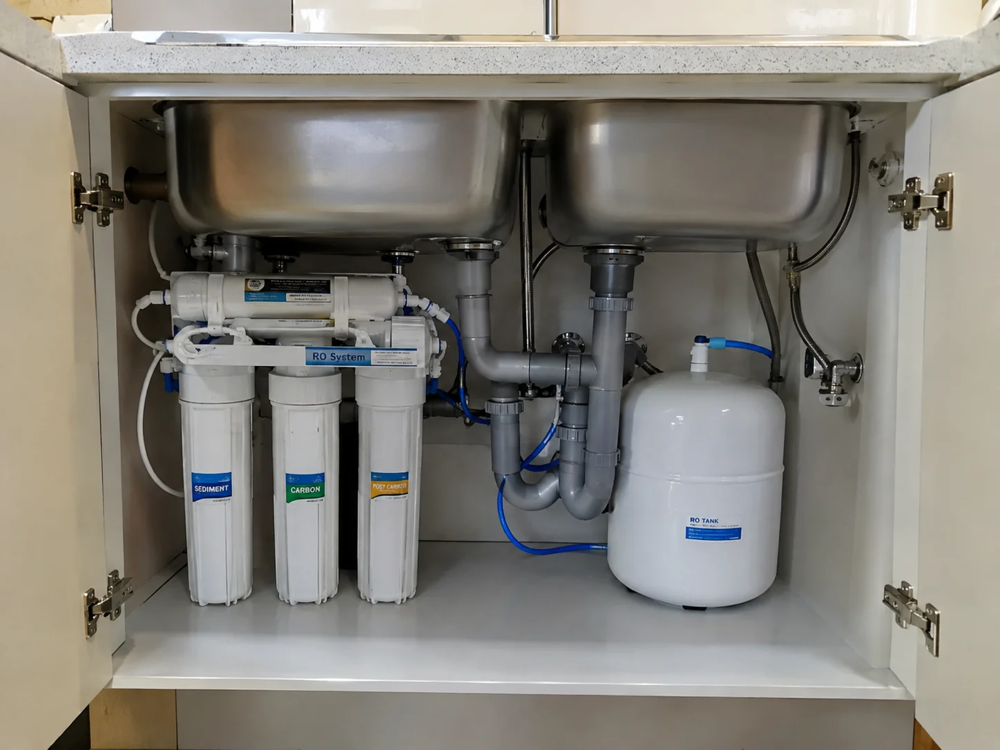 Under-sink reverse osmosis system with storage tank and filter cartridges installed in a kitchen cabinet